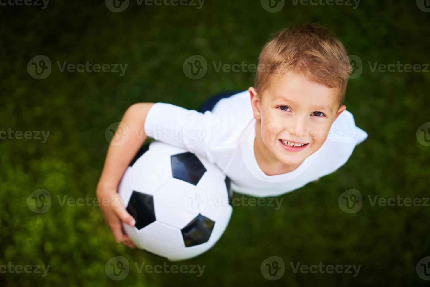 menino praticando futebol ao ar livre foto