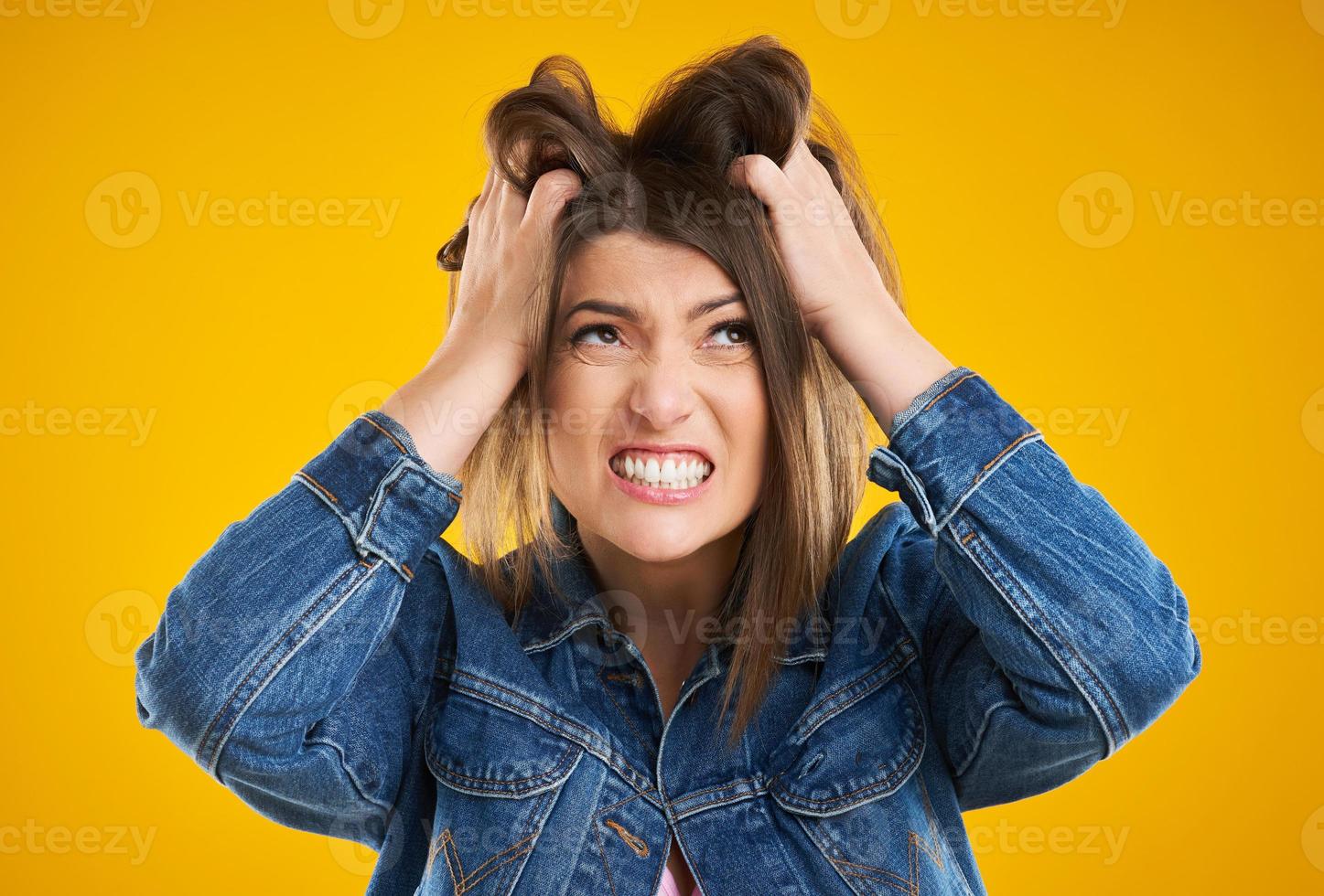 mulher infeliz em jaqueta jeans sobre fundo amarelo foto