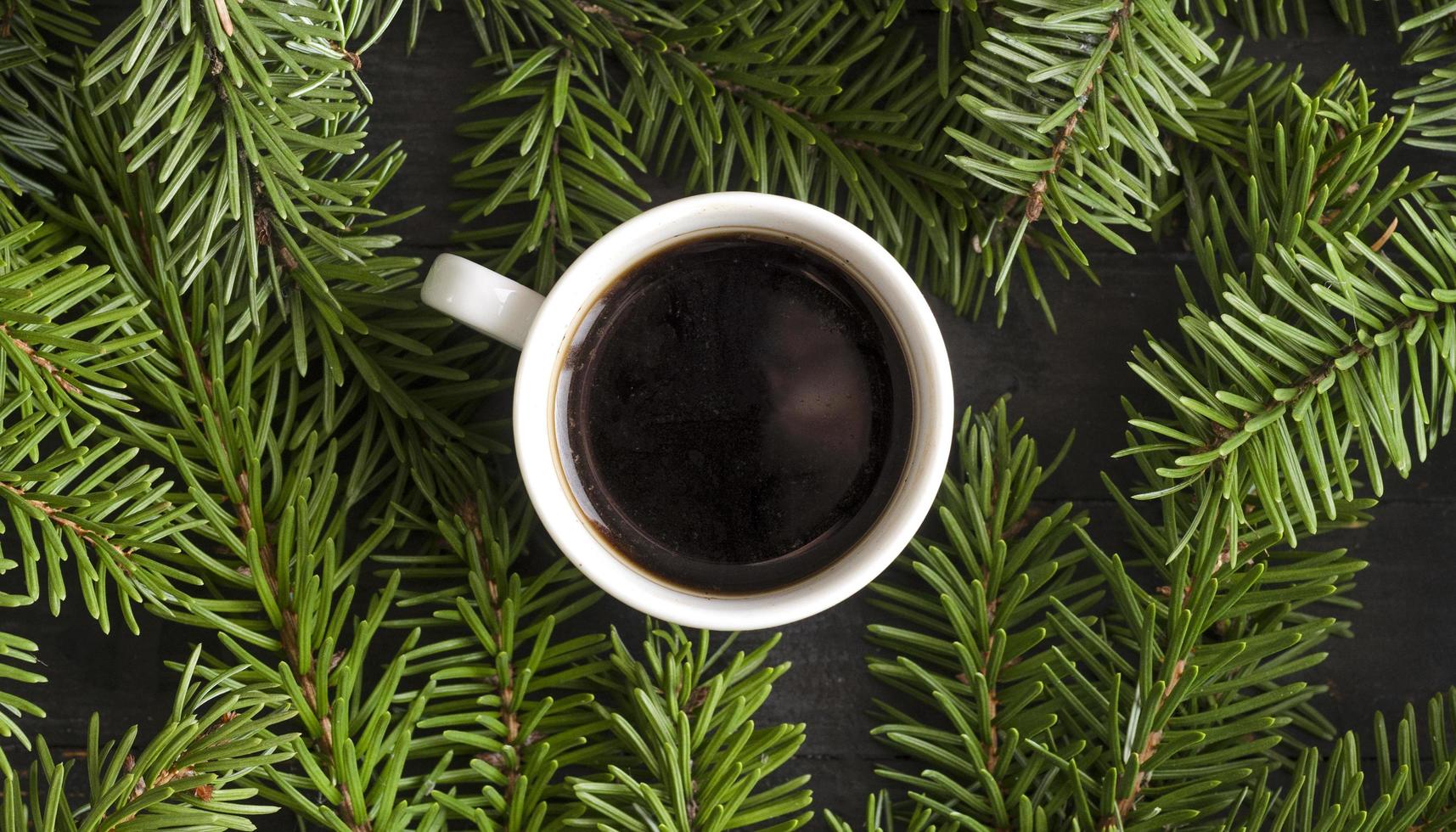 café de natal. uma xícara de café no fundo da árvore do abeto, vista superior. foto