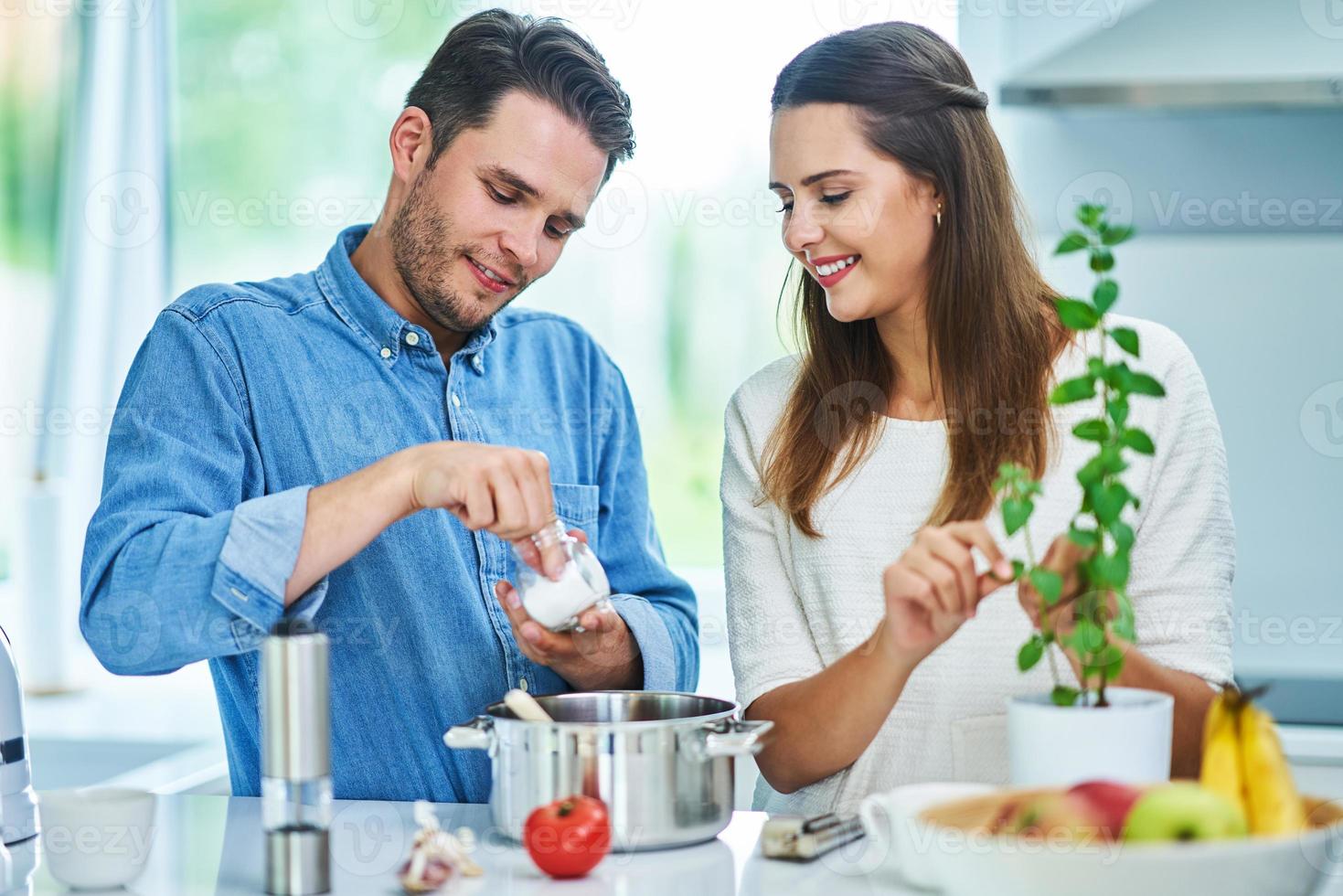 casal adulto cozinhando juntos em casa foto