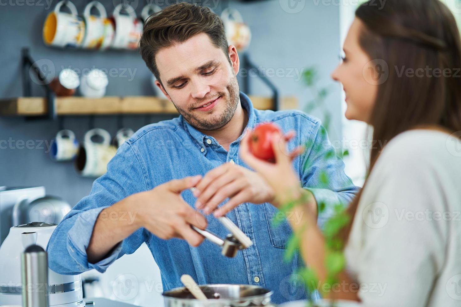 casal adulto cozinhando juntos em casa foto