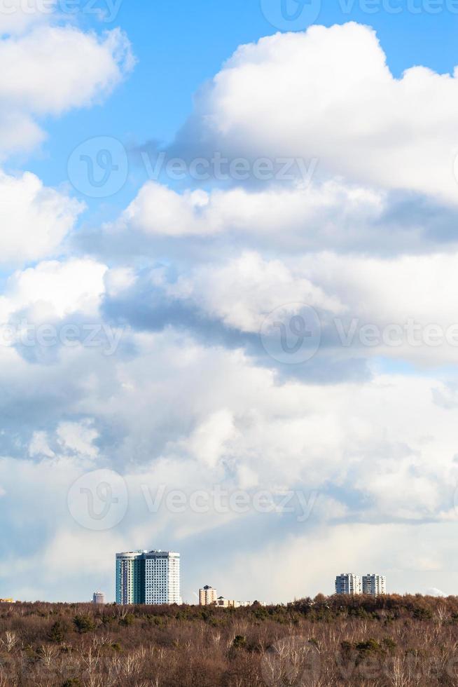 nuvens cumulus no céu sobre edifícios e bosques foto