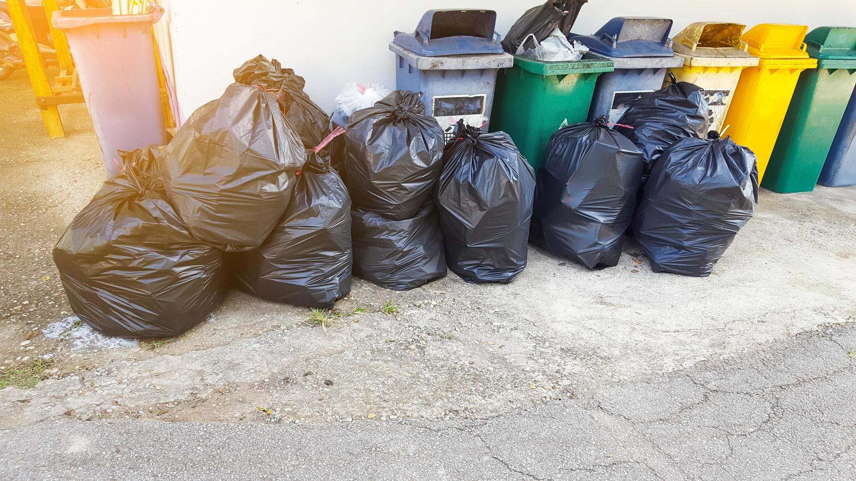 sacos de lixo de plástico preto no chão à espera de reciclar foto