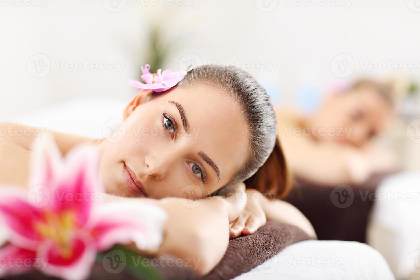 duas belas mulheres recebendo massagem no spa foto