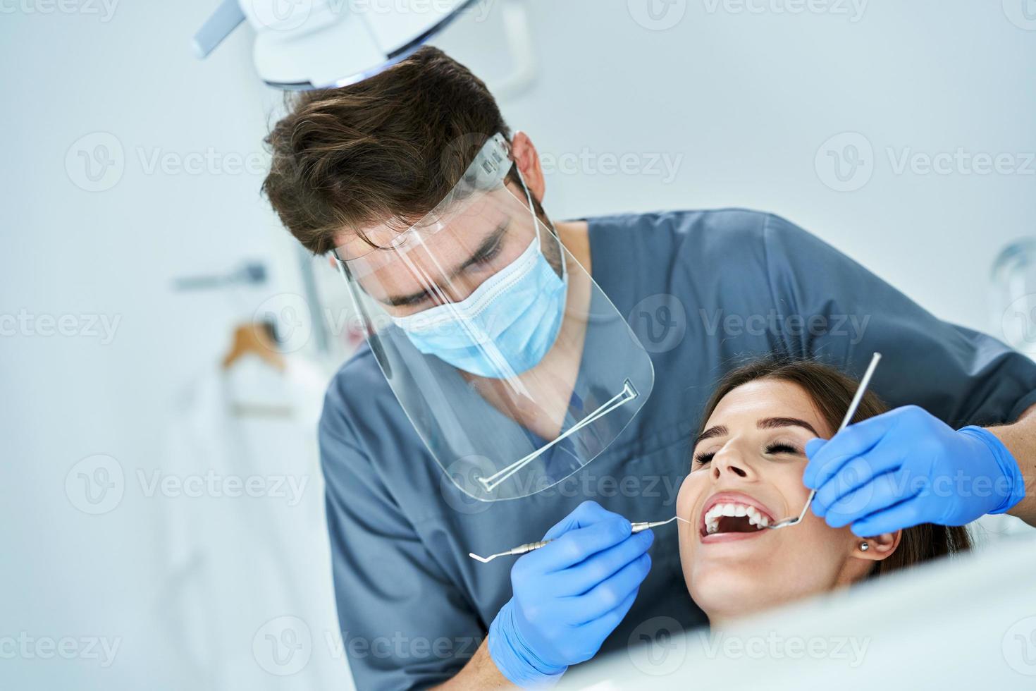dentista masculino e mulher no consultório do dentista foto