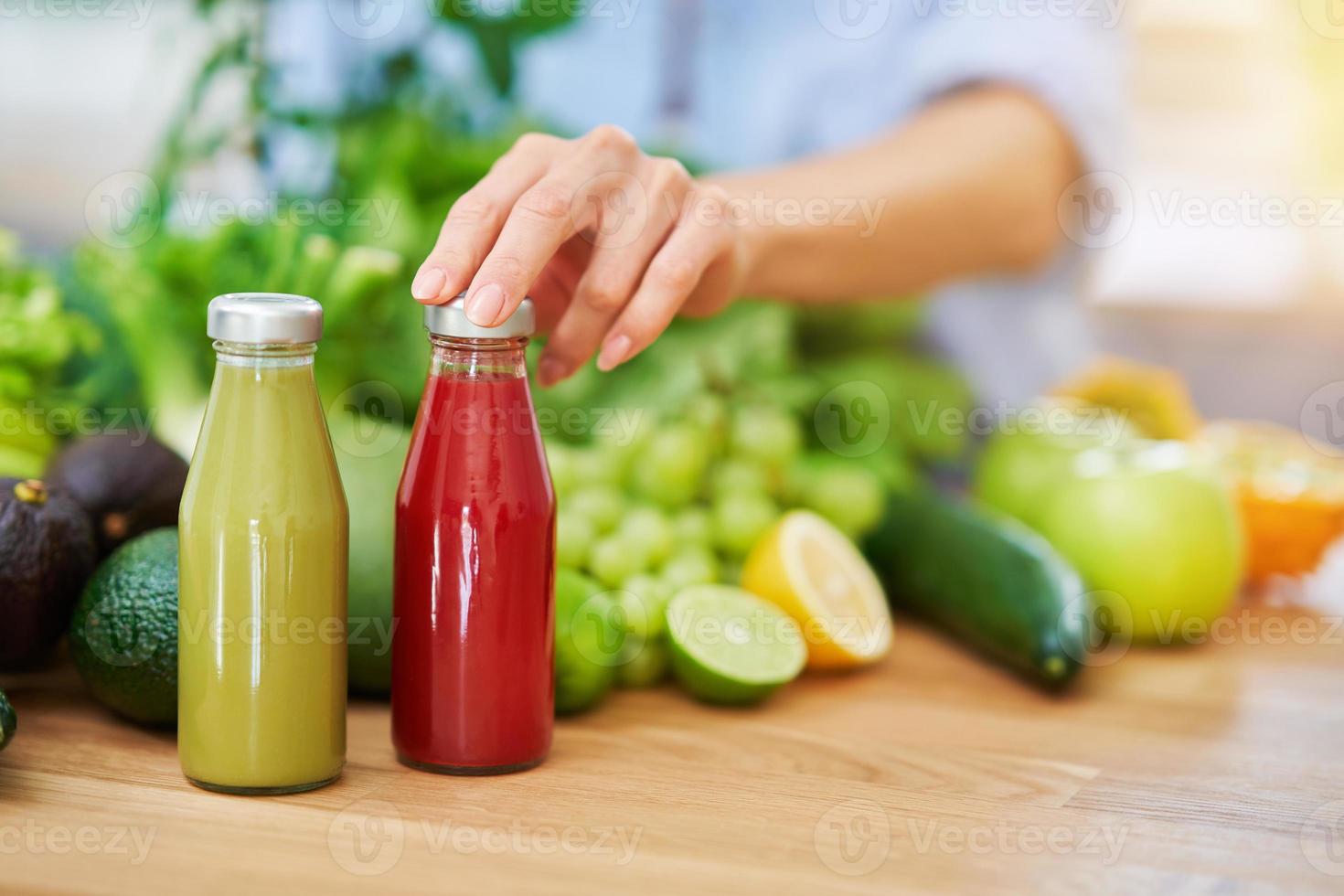 mulher adulta saudável com comida verde na cozinha foto