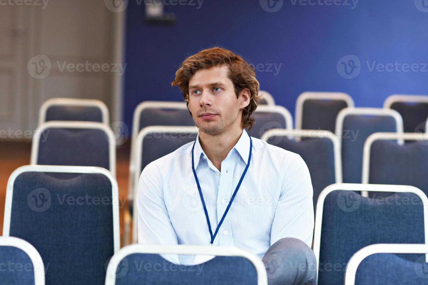 jovem sentado sozinho na sala de conferências foto