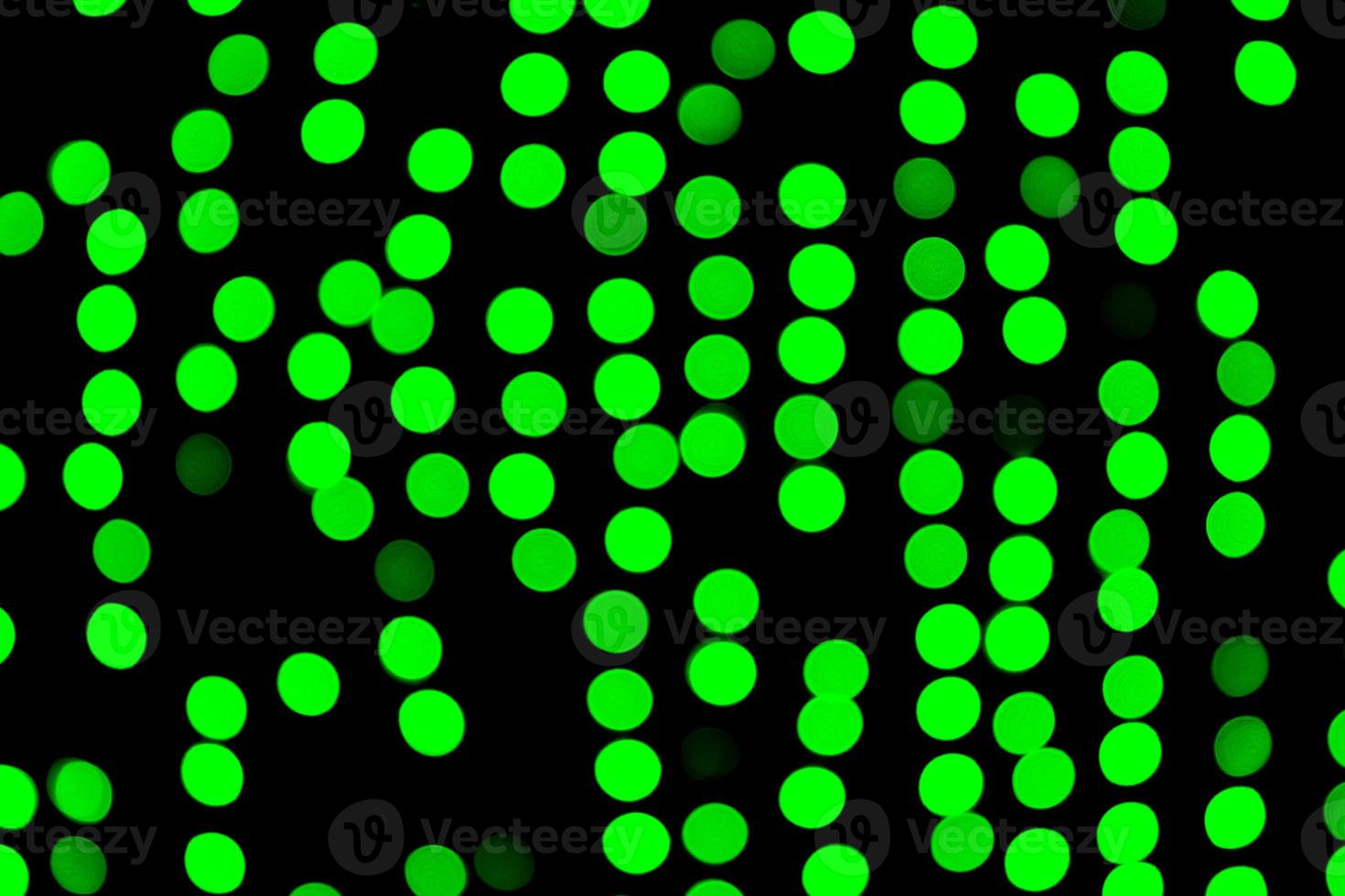 bokeh verde abstrato sem foco sobre fundo preto. desfocado e desfocado muitas luzes redondas foto