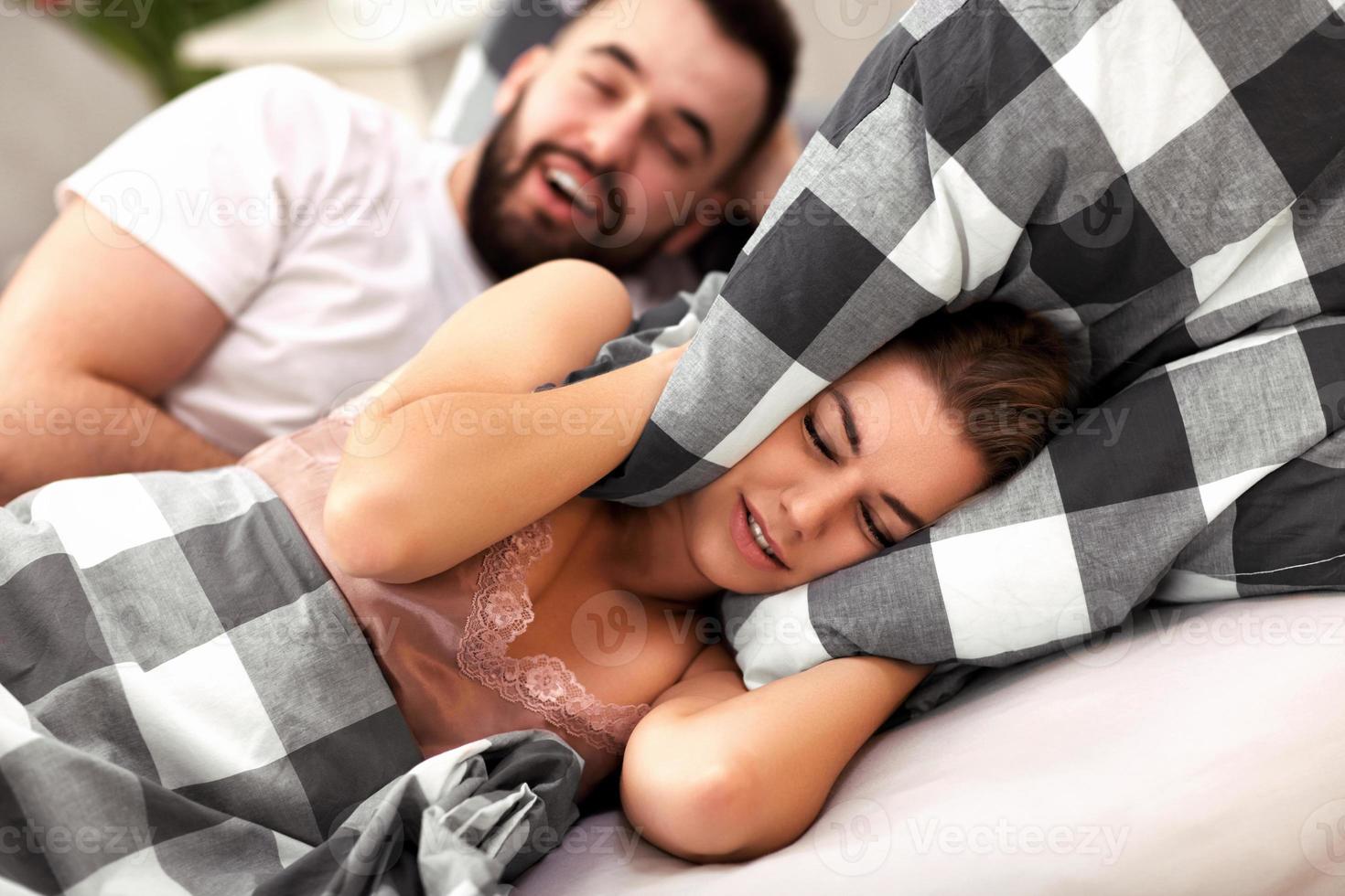 casal adulto que sofre de problema de ronco na cama foto