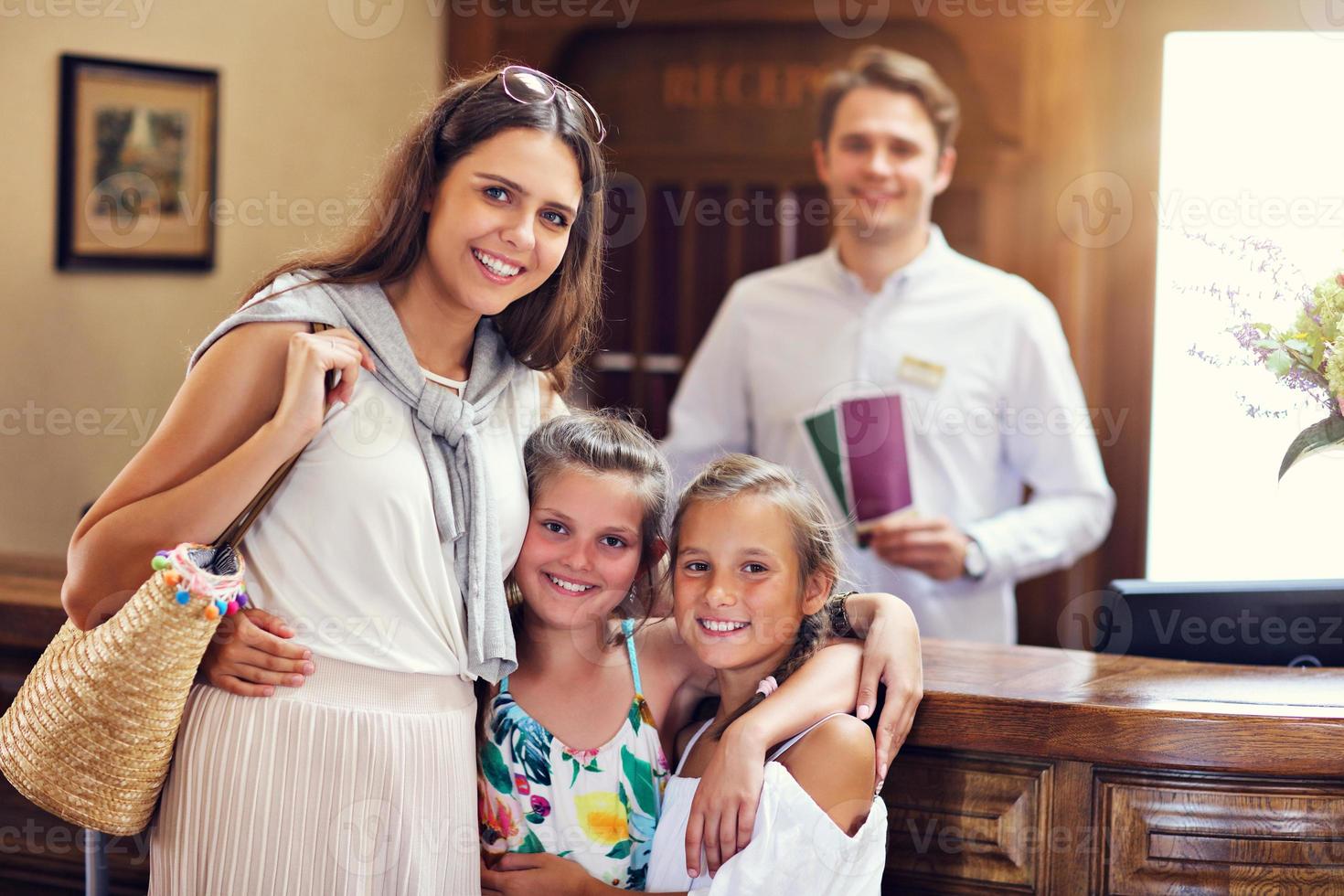 família feliz fazendo check-in no hotel na recepção foto