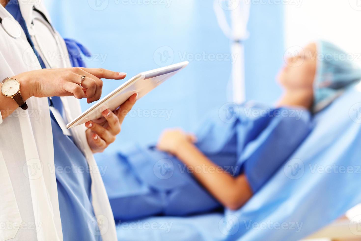 médico em pé com tablet na frente de paciente do sexo feminino no hospital foto