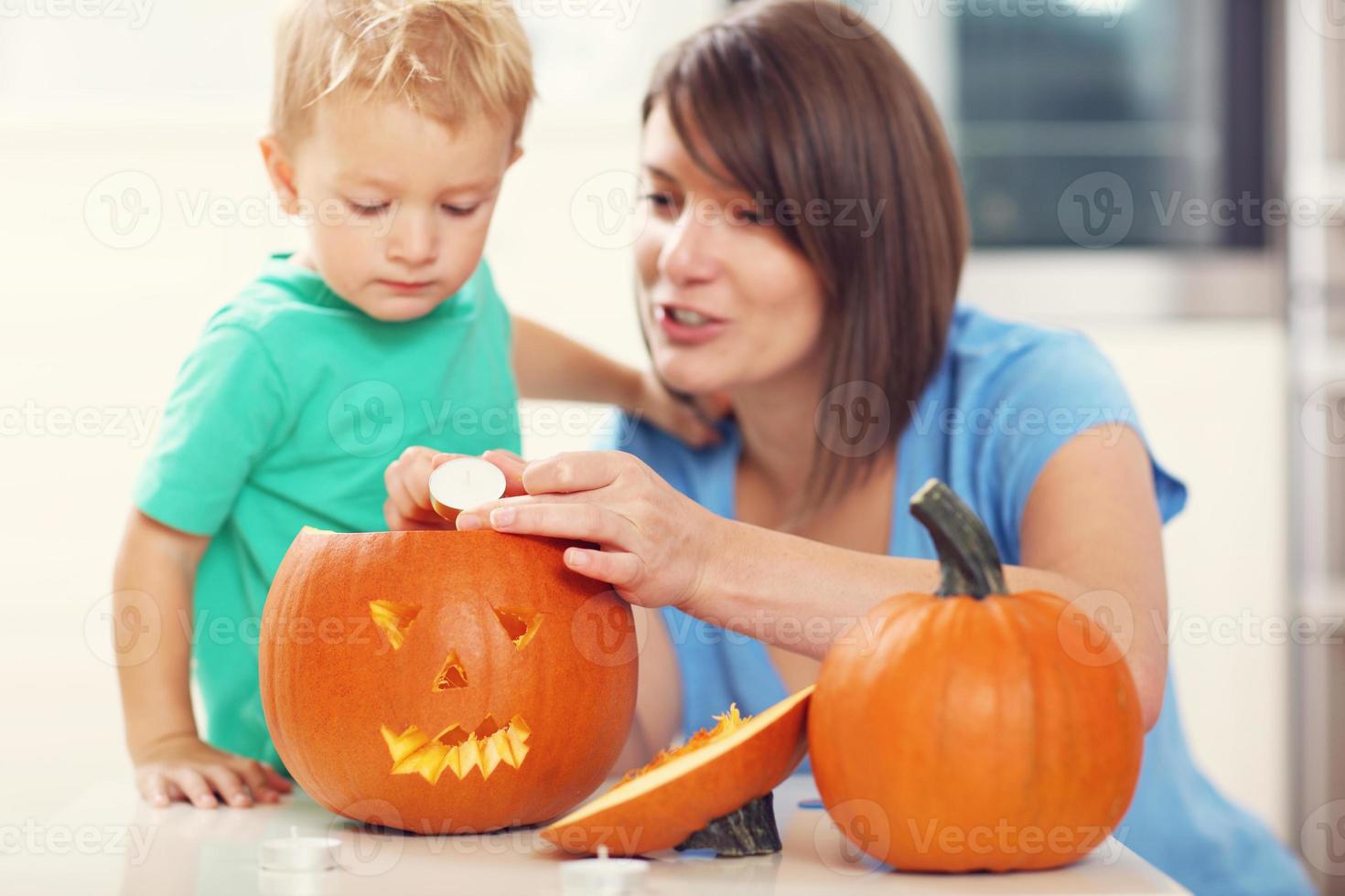 mãe e filho preparando jack-o-lantern para o halloween foto