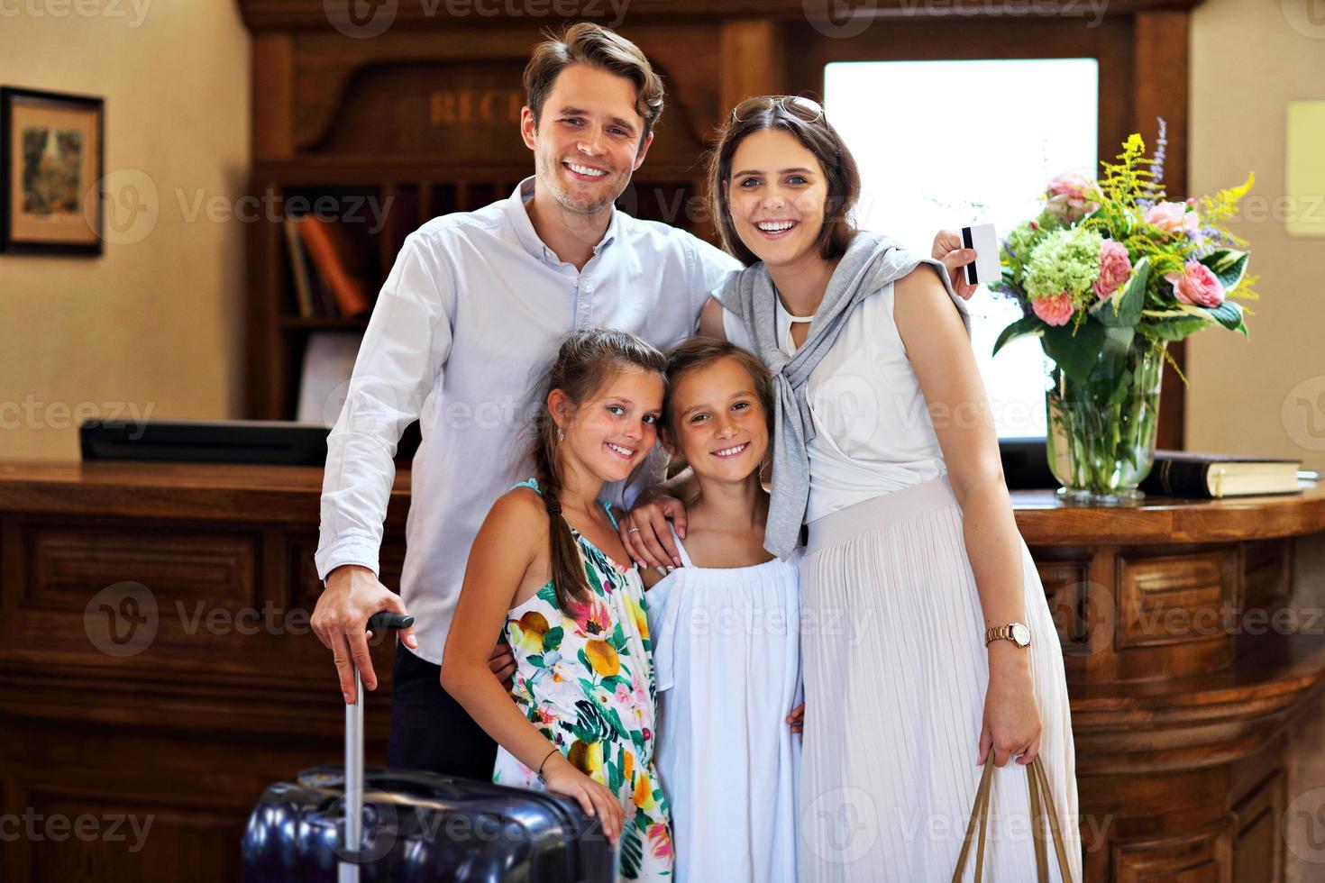 família feliz fazendo check-in no hotel na recepção foto