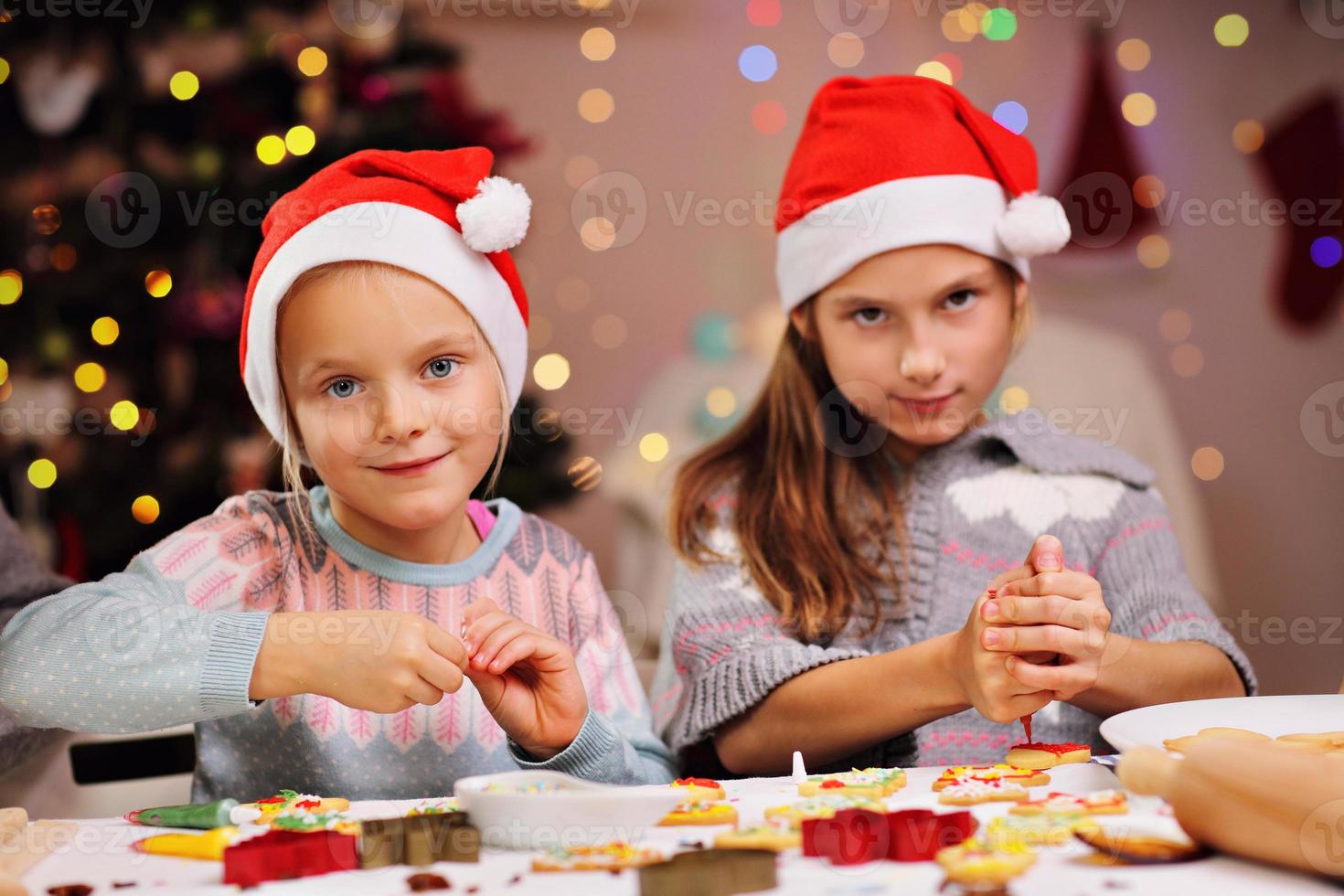 irmãzinhas felizes preparando biscoitos de natal foto