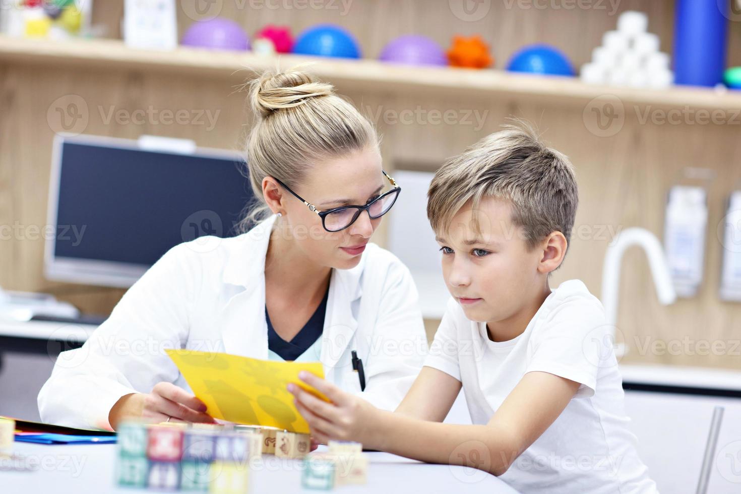 psicólogo infantil trabalhando com menino no escritório foto