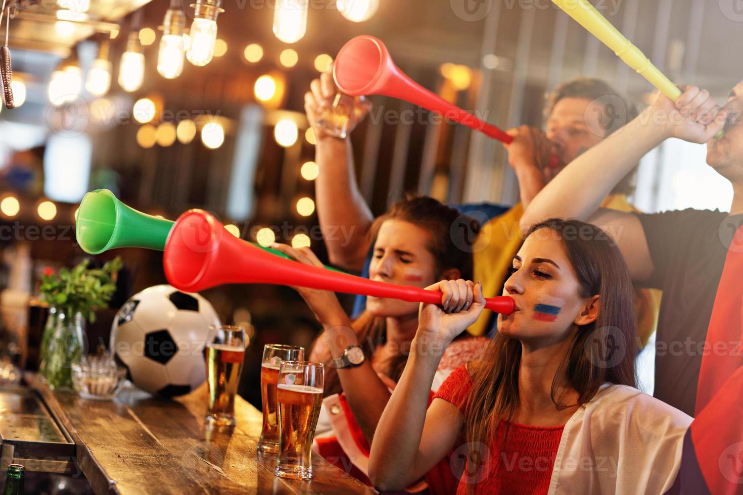 grupo de amigos assistindo futebol no pub foto