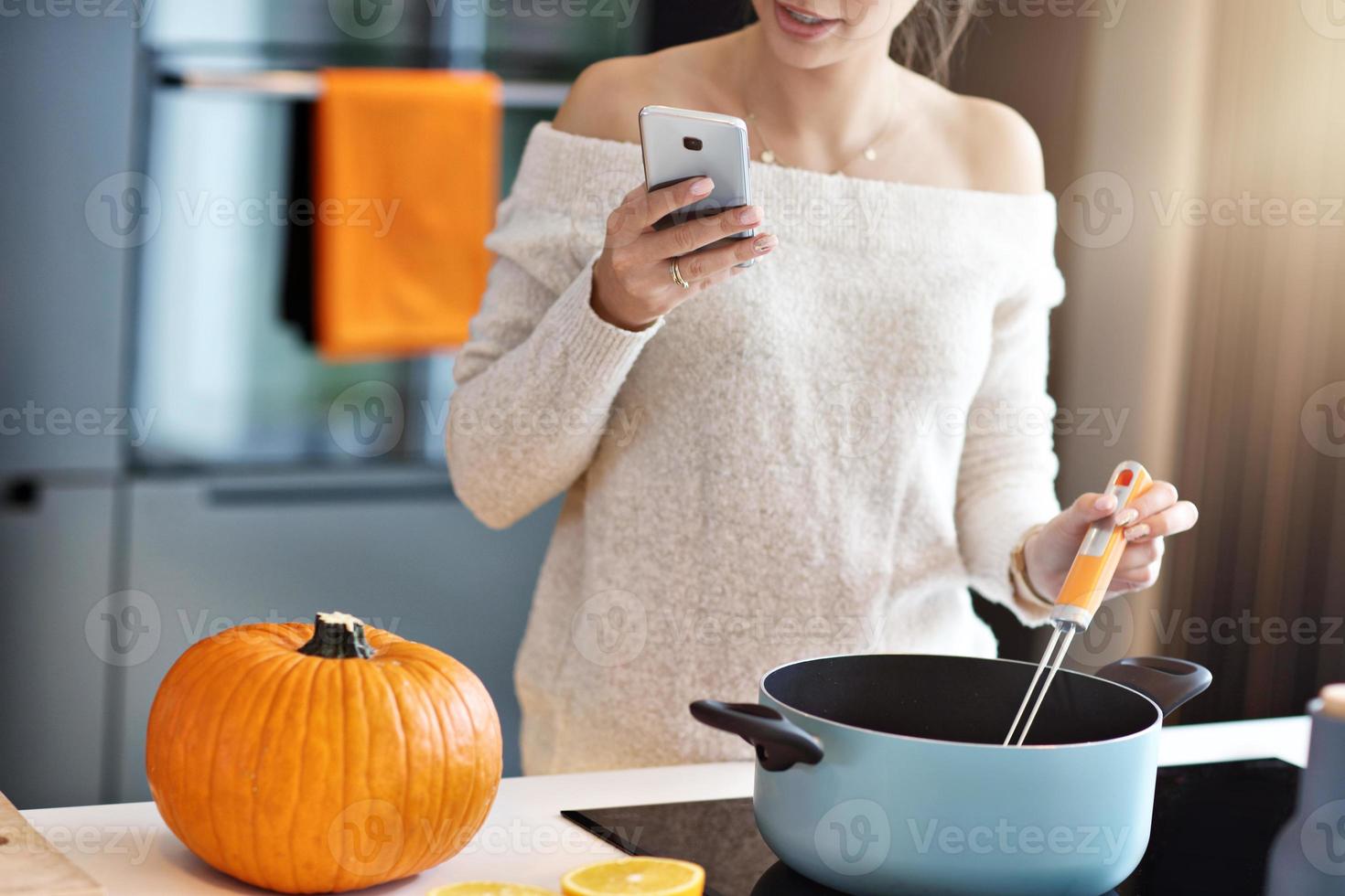 mulher adulta na cozinha preparando pratos de abóbora para o halloween foto