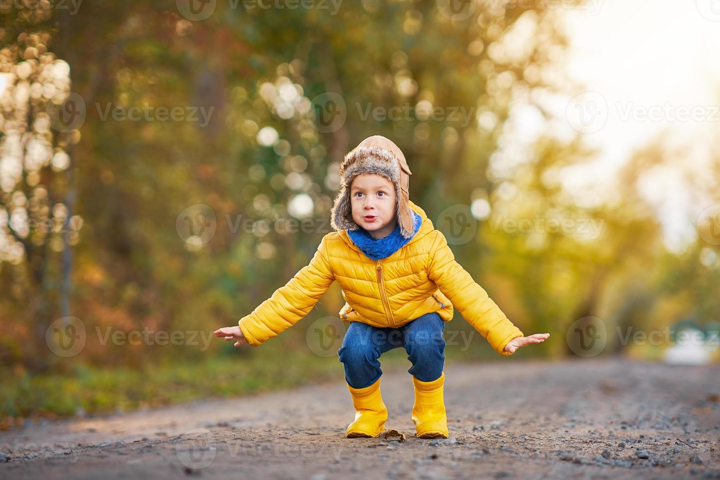 menino criança feliz brincando lá fora no outono foto