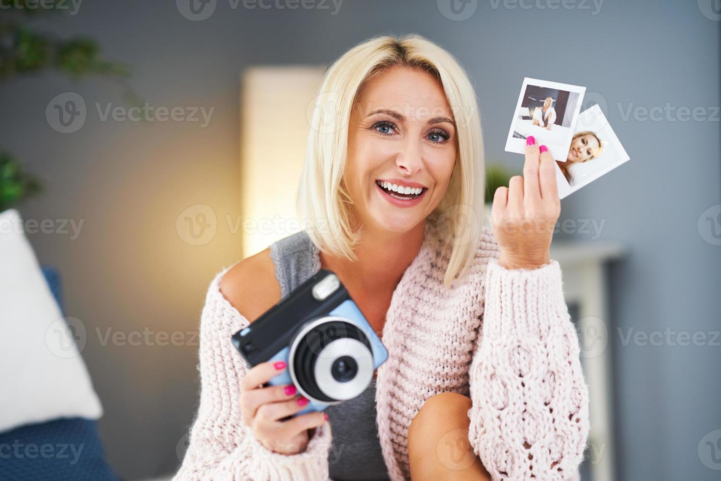 mulher bonita adulta tirando foto instantânea em casa