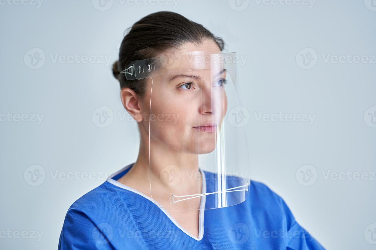 fechar o retrato do médico feminino ou enfermeira usando escudo facial foto