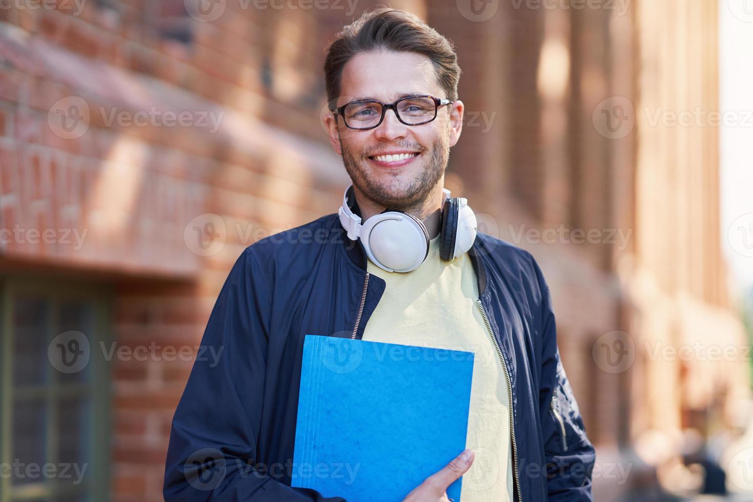 estudante do sexo masculino no campus estudando ao ar livre foto