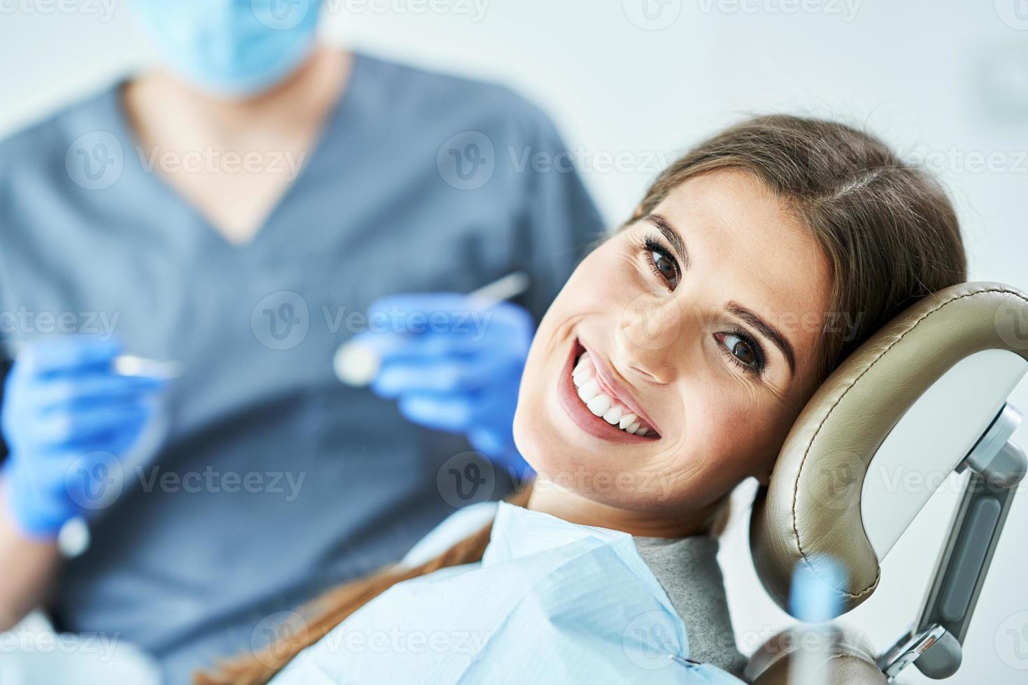 dentista masculino e mulher no consultório do dentista foto