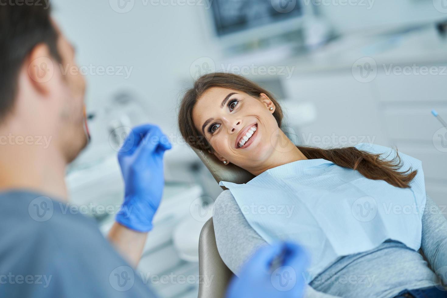 dentista masculino e mulher no consultório do dentista foto