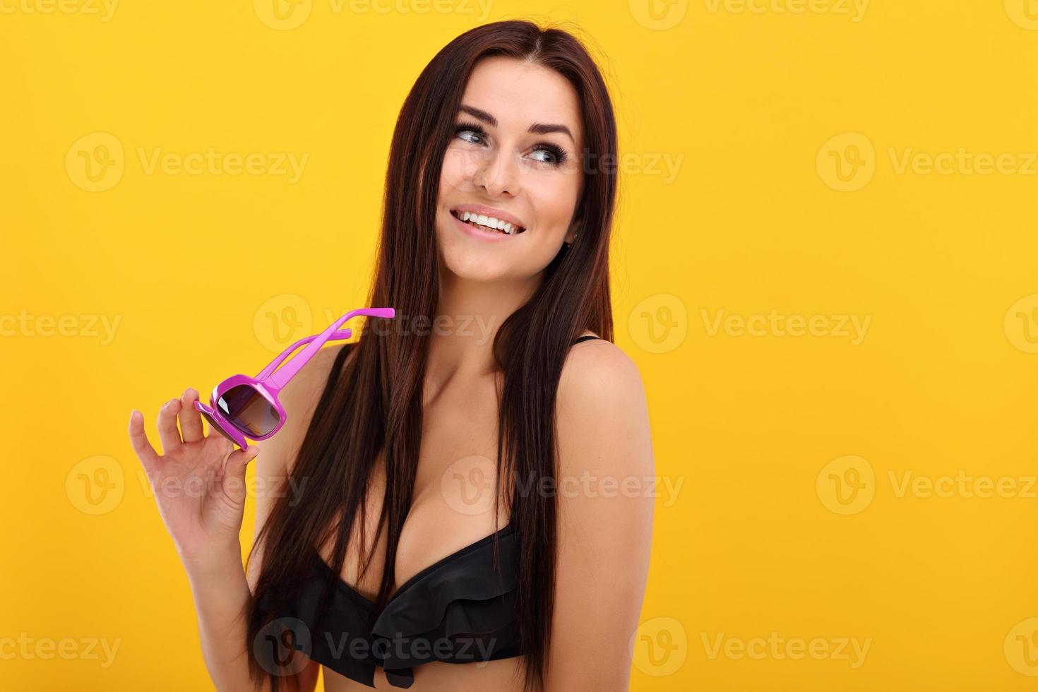 mulher sexy em biquíni posando contra fundo amarelo foto