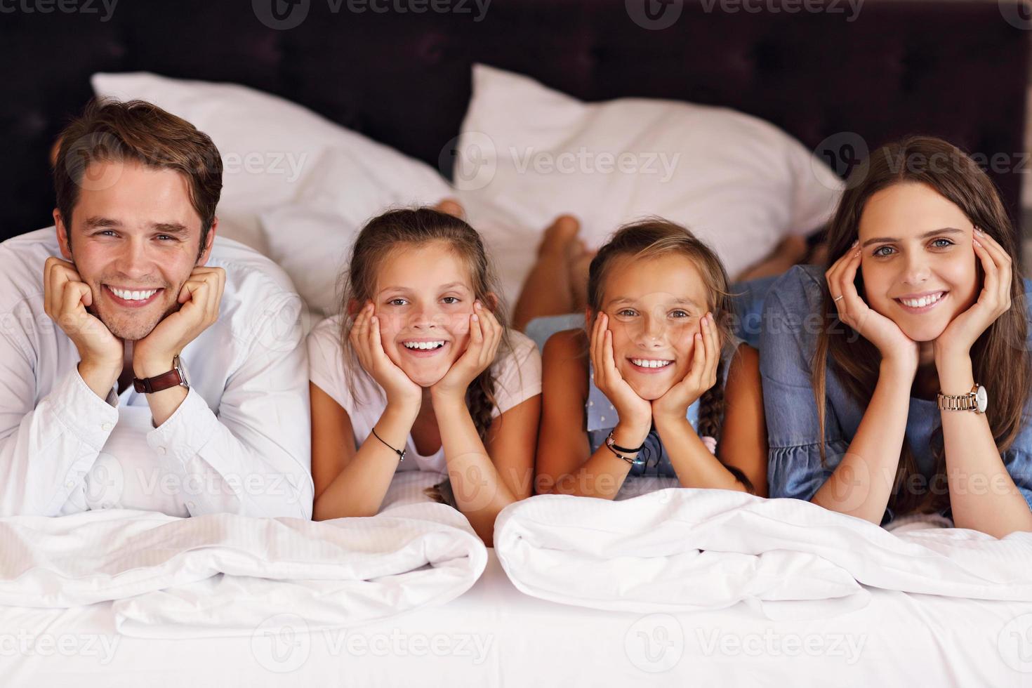 família feliz relaxando no quarto de hotel foto