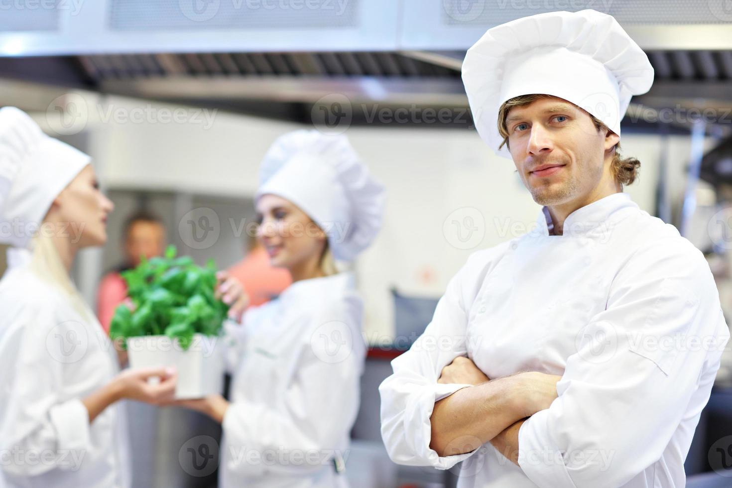 chefs ocupados trabalhando na cozinha do restaurante foto