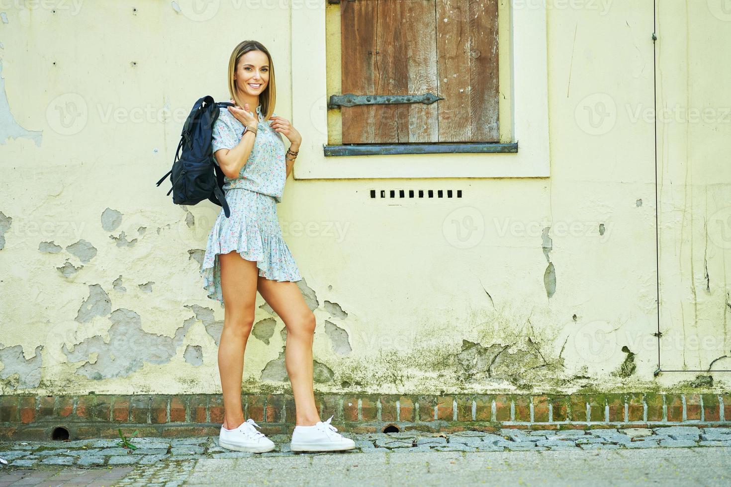 uma mulher parada na frente de um prédio foto