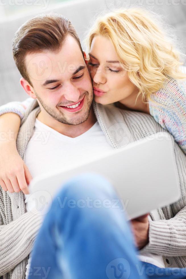 casal romântico com laptop na sala de estar foto