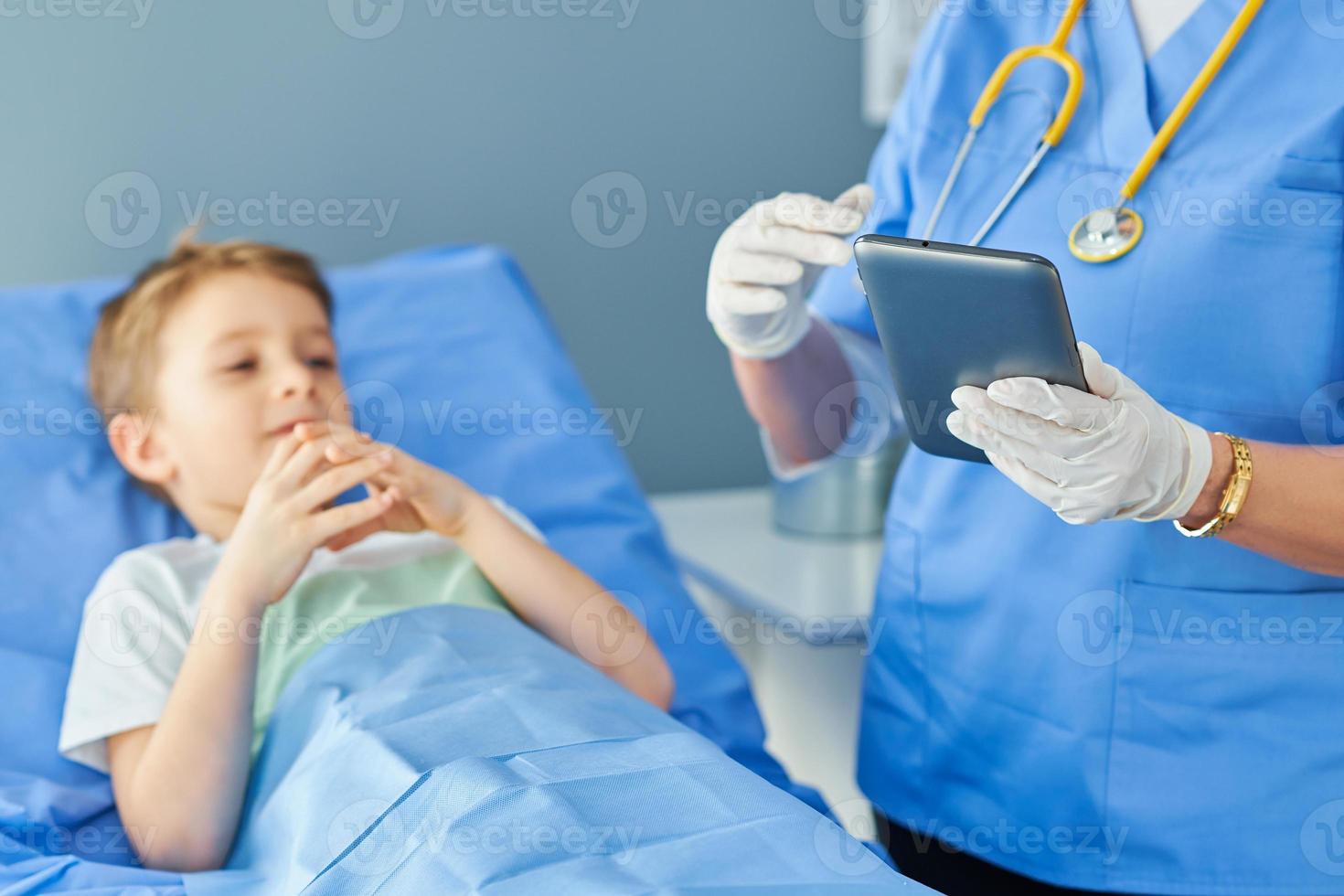 mulher adulta e jovem paciente na cama do hospital foto