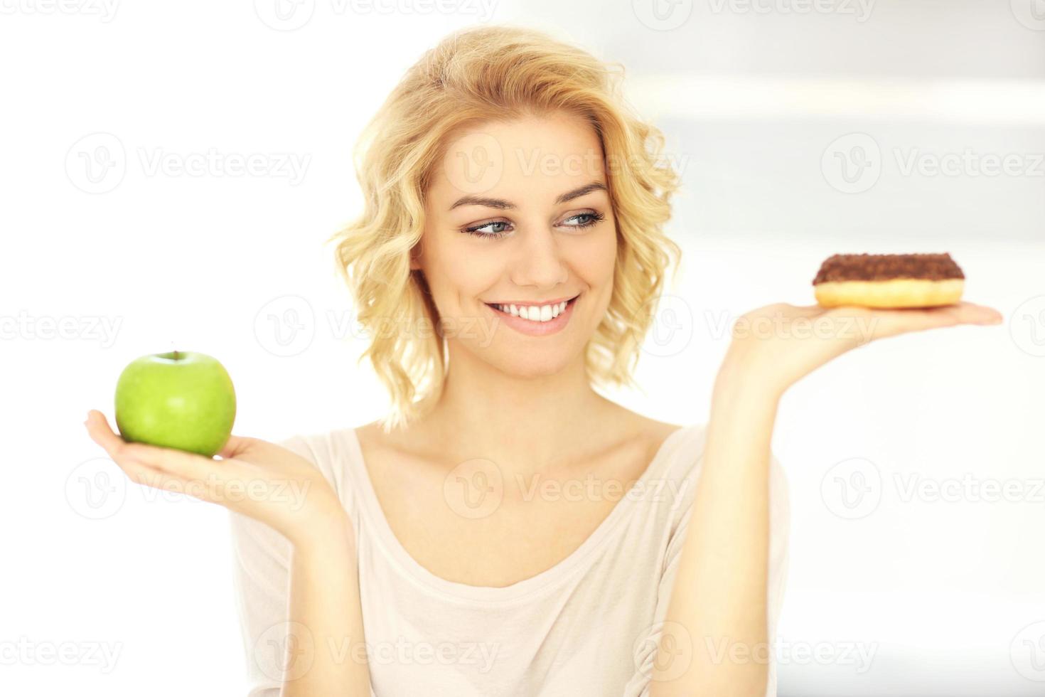 mulher feliz com donut e maçã foto