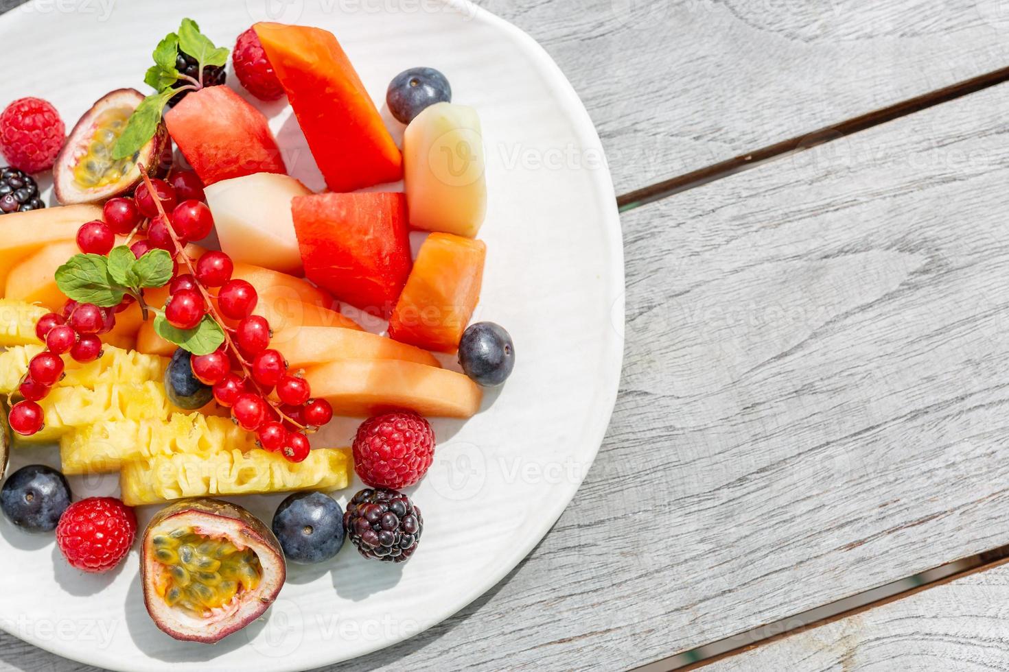 salada de frutas, fundo de madeira simples e frutas frescas. foto