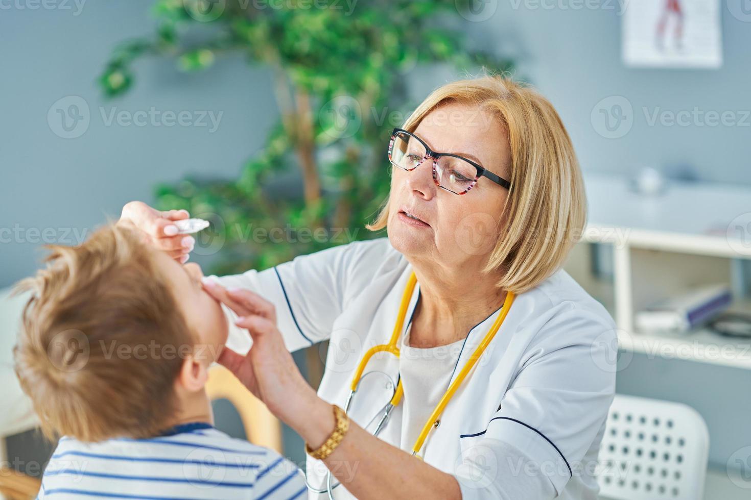 médico pediatra examinando crianças na clínica foto