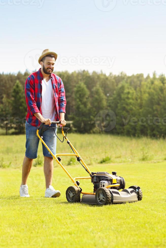 homem cortando a grama foto