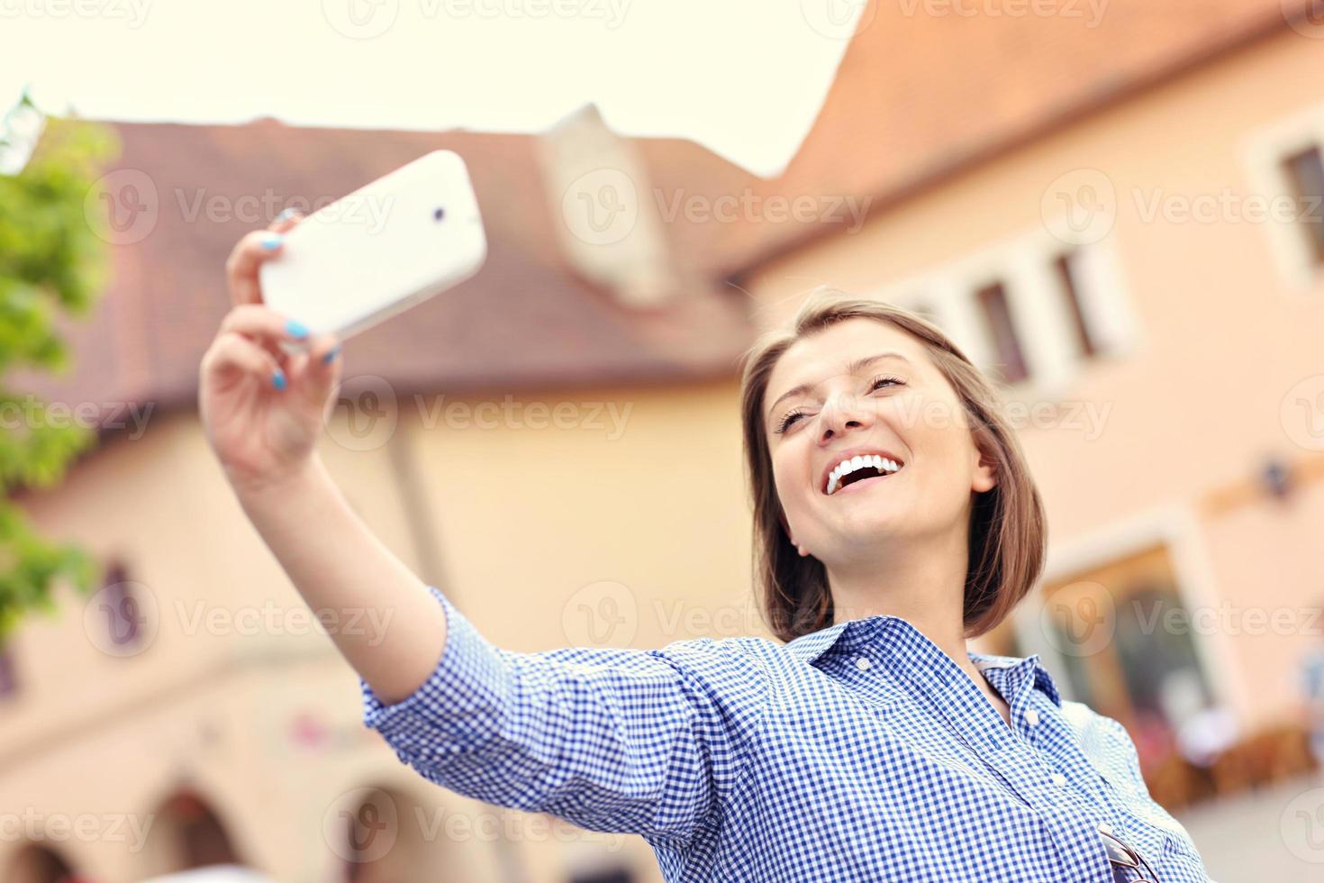 mulher feliz tomando selfie em uma cidade foto