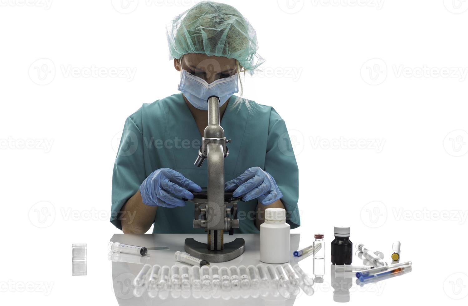 cientista em luvas médicas azuis e uniforme aprendendo amostras covid-19 com microscópio em laboratório. foto