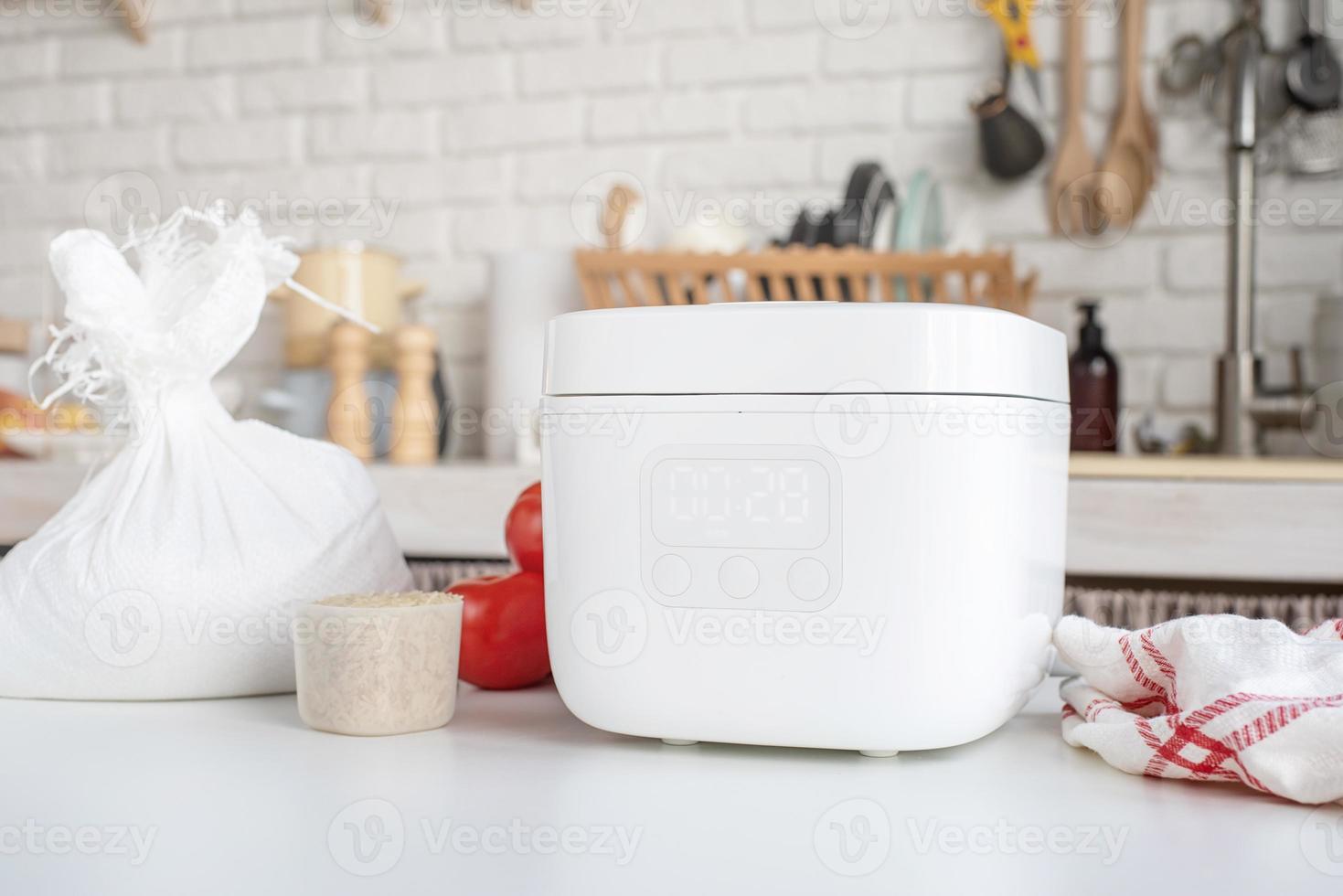 panela de arroz elétrica na bancada de madeira na cozinha foto