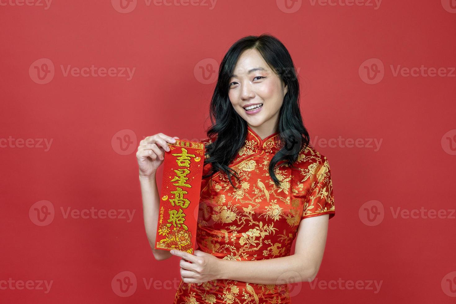 mulher asiática segurando fortuna vermelha abençoando palavra chinesa que significa ser abençoado por uma estrela da sorte isolada em fundo vermelho para o conceito de celebração do ano novo chinês foto