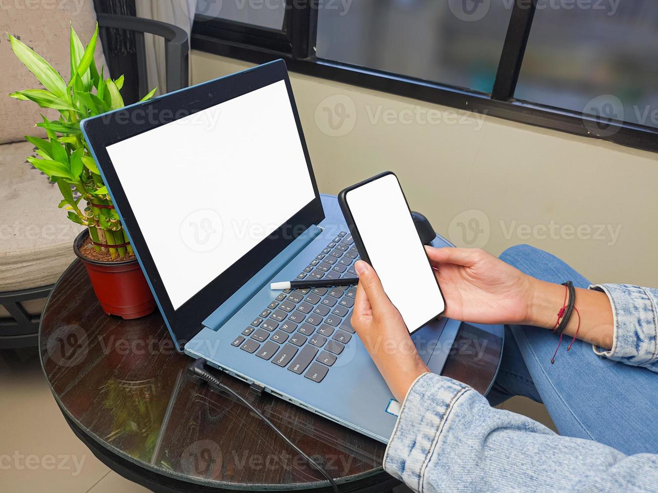 computador, imagem de maquete de telefone de tela em branco com fundo branco para publicidade, mão de mulher usando laptop e celular na mesa em cafe.mockup foto