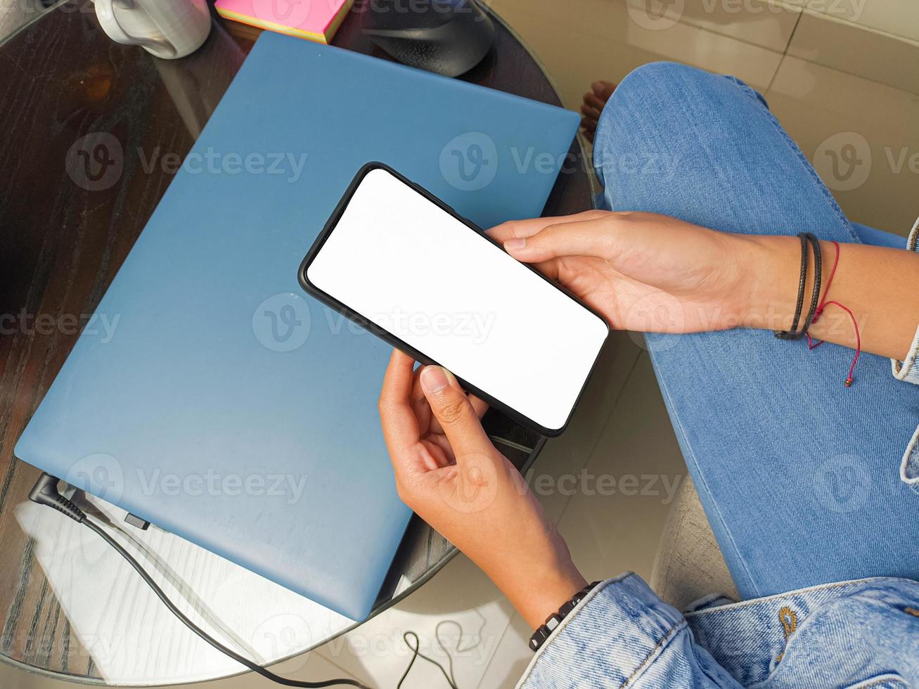 close-up de uma mão de mulher segurando uma tela branca de smartphone é .mockup em branco. foto