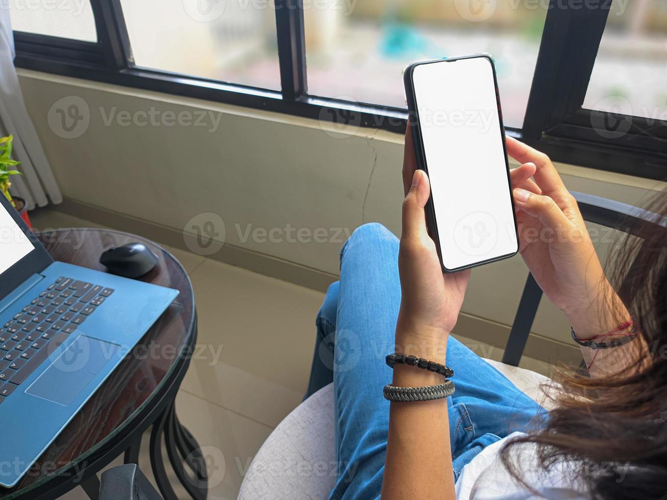 computador, imagem de maquete de telefone de tela em branco com fundo branco para publicidade, mão de mulher usando laptop e celular na mesa em cafe.mockup foto