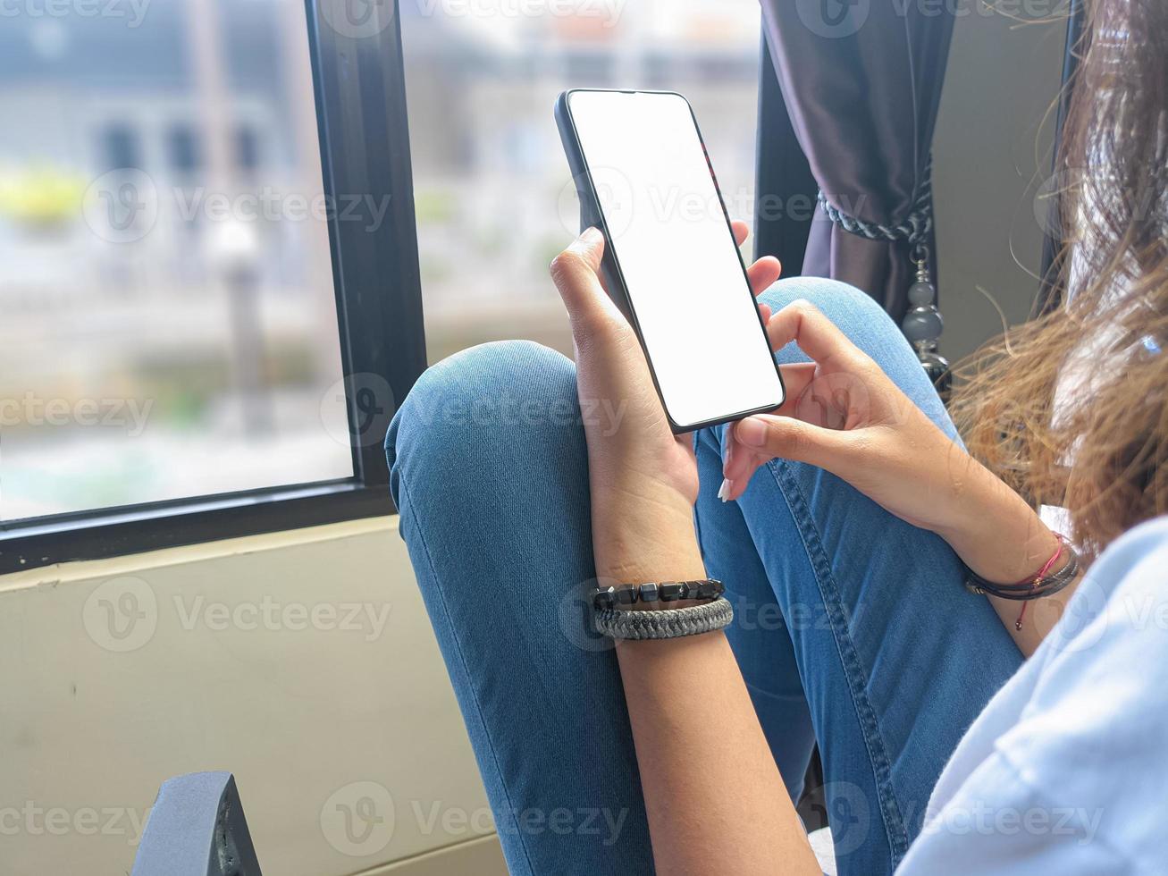 close-up de uma mão de mulher segurando uma tela branca de smartphone é .mockup em branco. foto