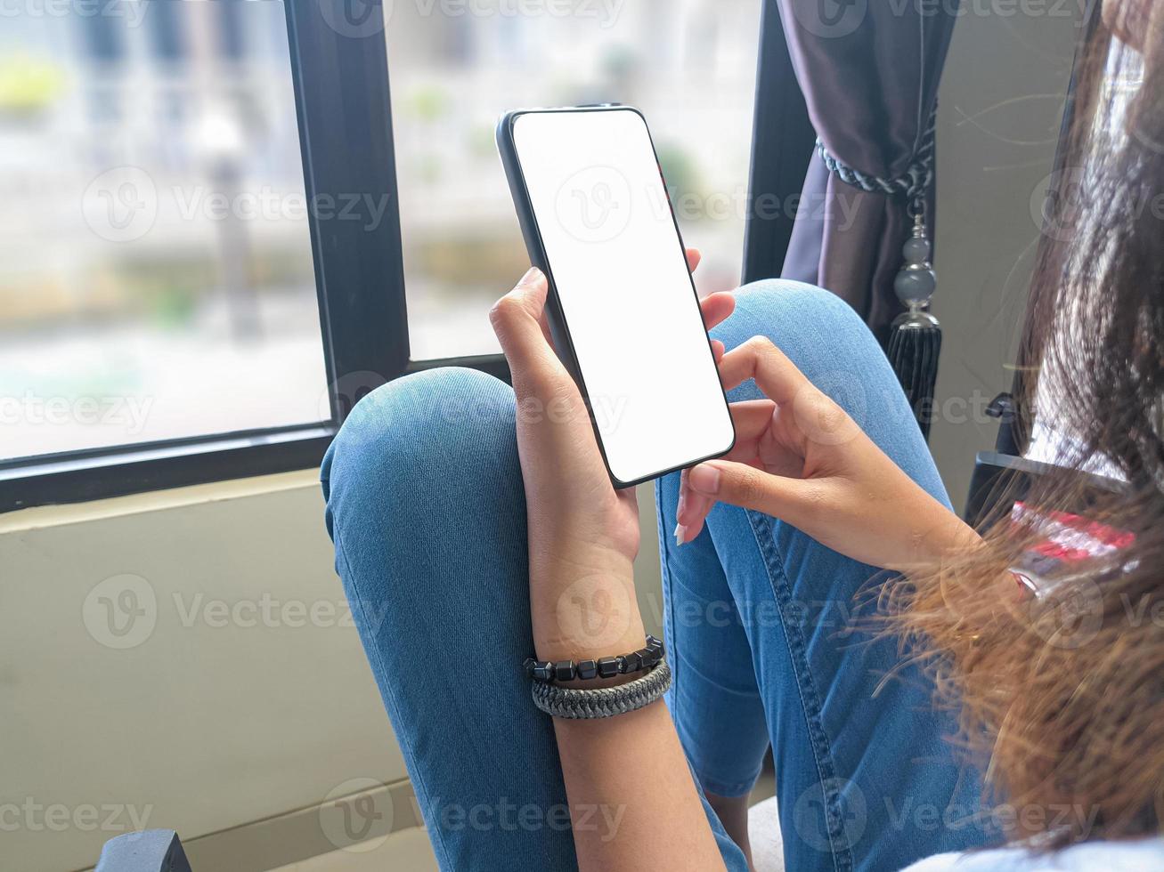 close-up de uma mão de mulher segurando uma tela branca de smartphone é .mockup em branco. foto