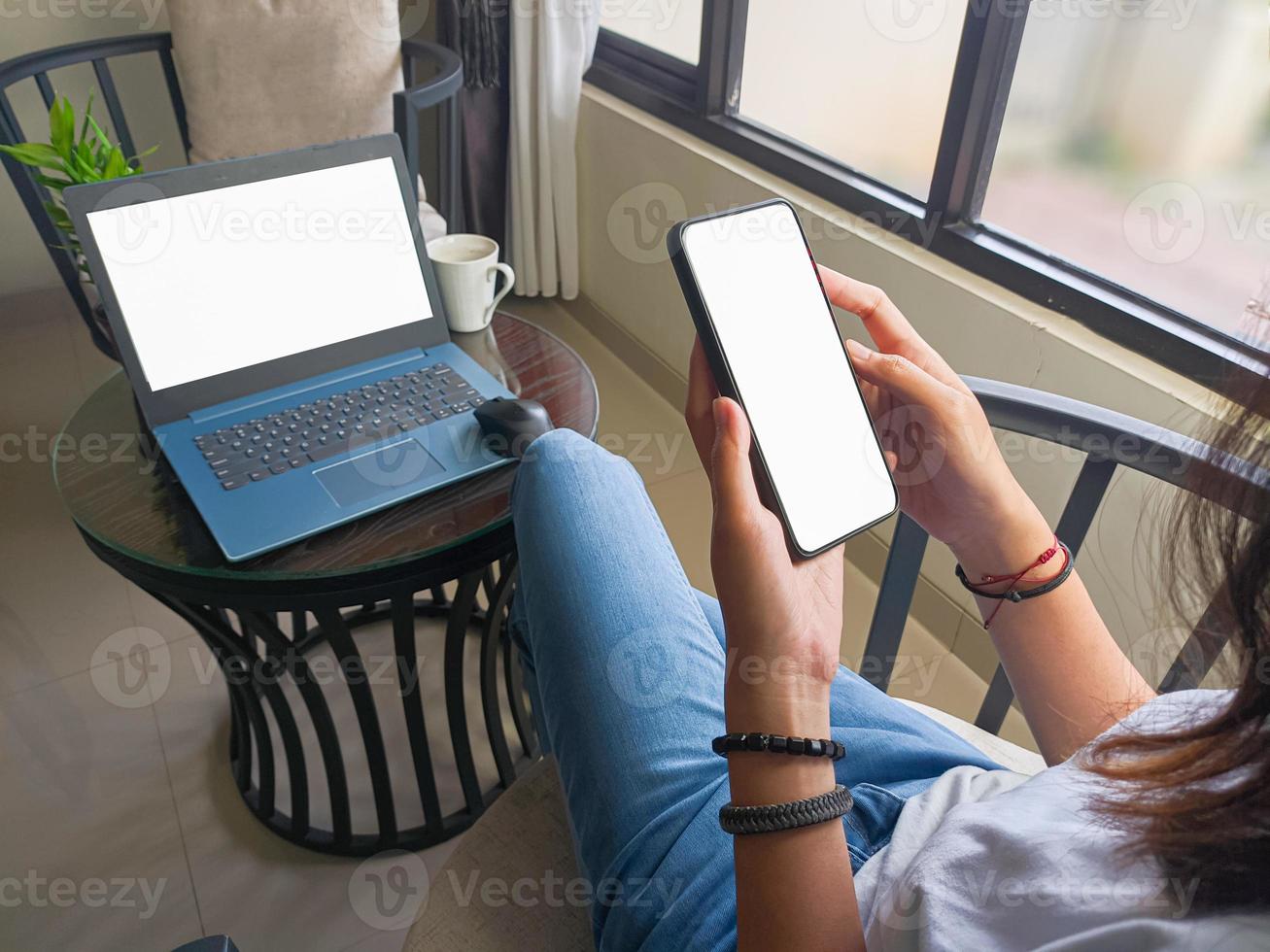 computador, imagem de maquete de telefone de tela em branco com fundo branco para publicidade, mão de mulher usando laptop e celular na mesa em cafe.mockup foto