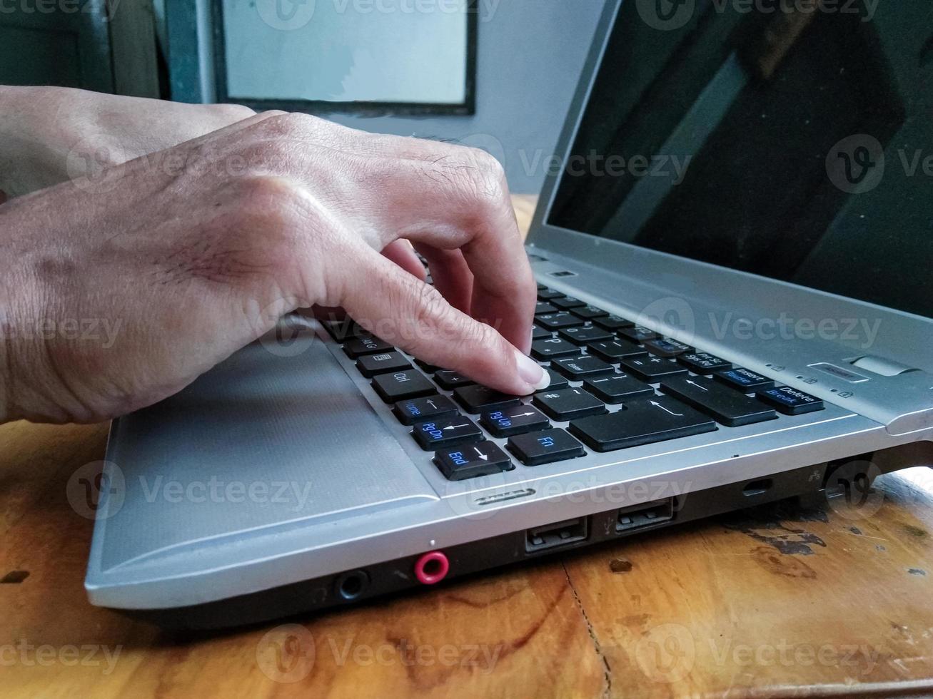 mão de empresário trabalhando com laptop na mesa de madeira foto