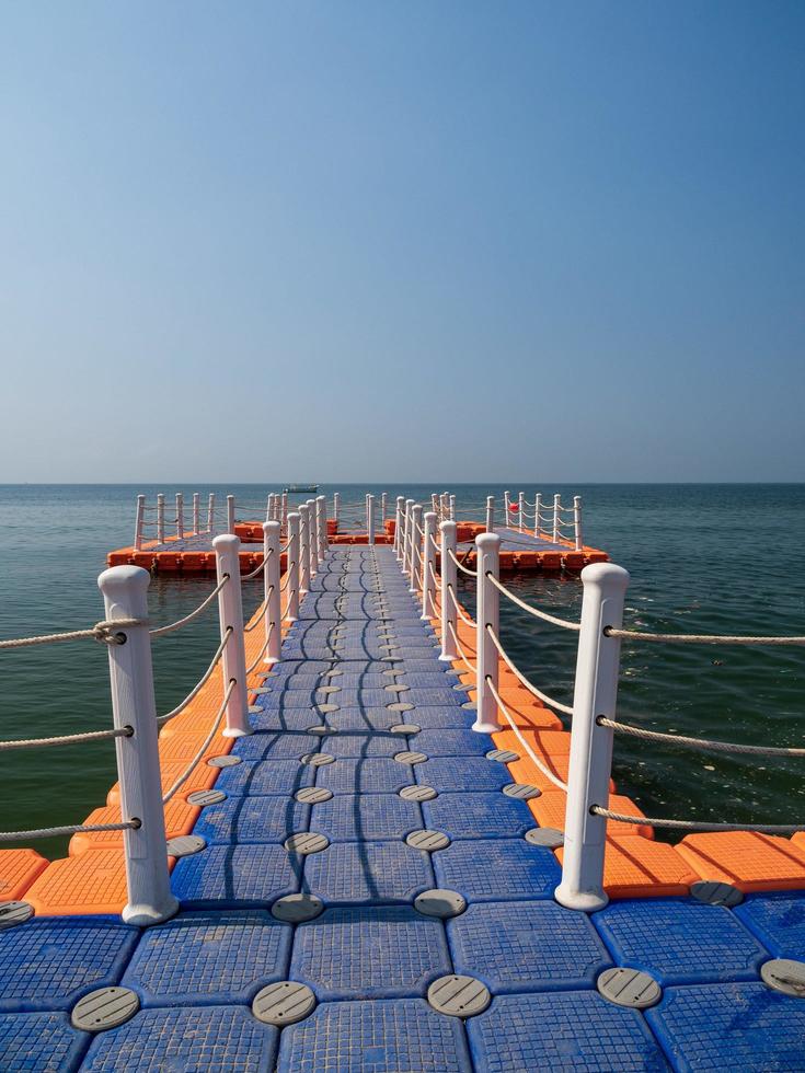 píeres flutuantes ao longo da costa são locais para caminhadas de turistas. pontão de plástico de barco de amarração que flutua na água do mar. azul vista para o mar fundo azul olhar onda calma paisagem ponto de vista verão natureza tropical foto