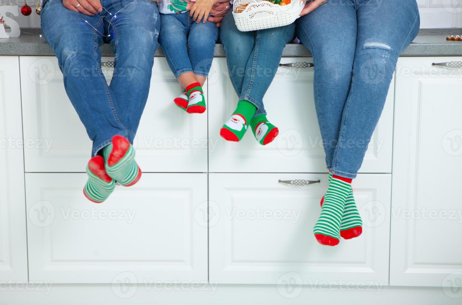 o conceito de uma família feliz vestida com meias de natal na cozinha foto